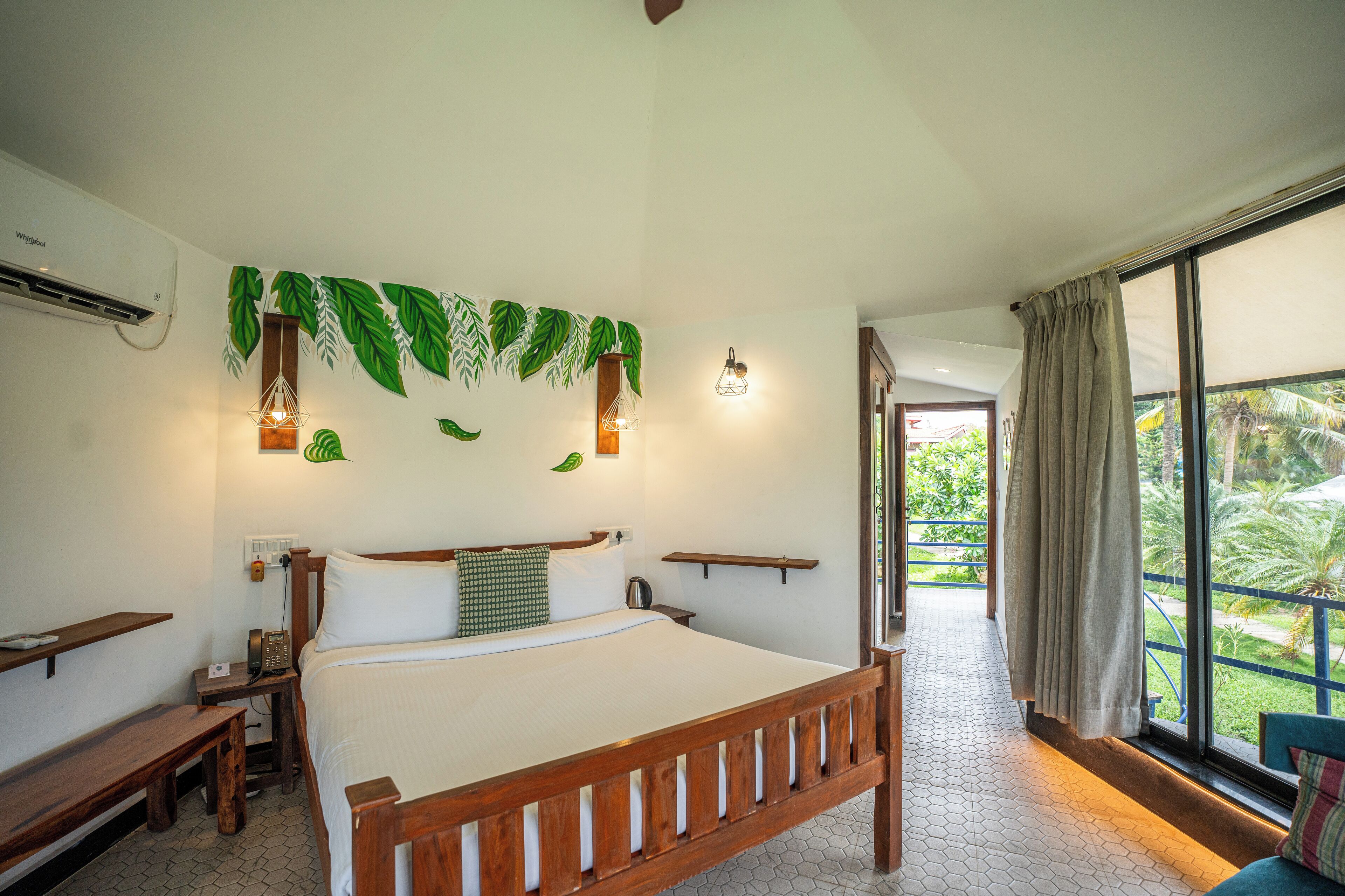 A bedroom with a wooden bed, a bedside table, a nightstand, a wall-mounted phone, and a window with curtains.