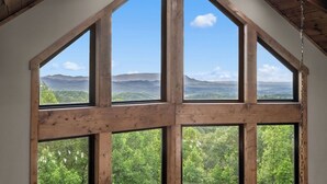 A room with large windows offering a view of a mountainous landscape.