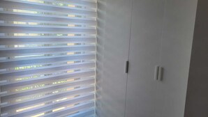 A room with a large wardrobe, a red carpet, and a window with blinds. - beb dei sogni (Cosenza)