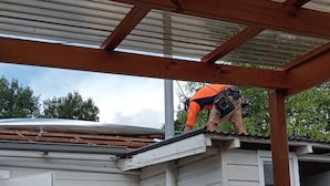 A person working on a roof under a metal roof structure. - This is New England! (Armidale)