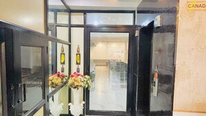 A hotel entrance with a glass door, a green carpet, and a sign reading 'CANADA'. - Hotel Devine  (Zirakpur)