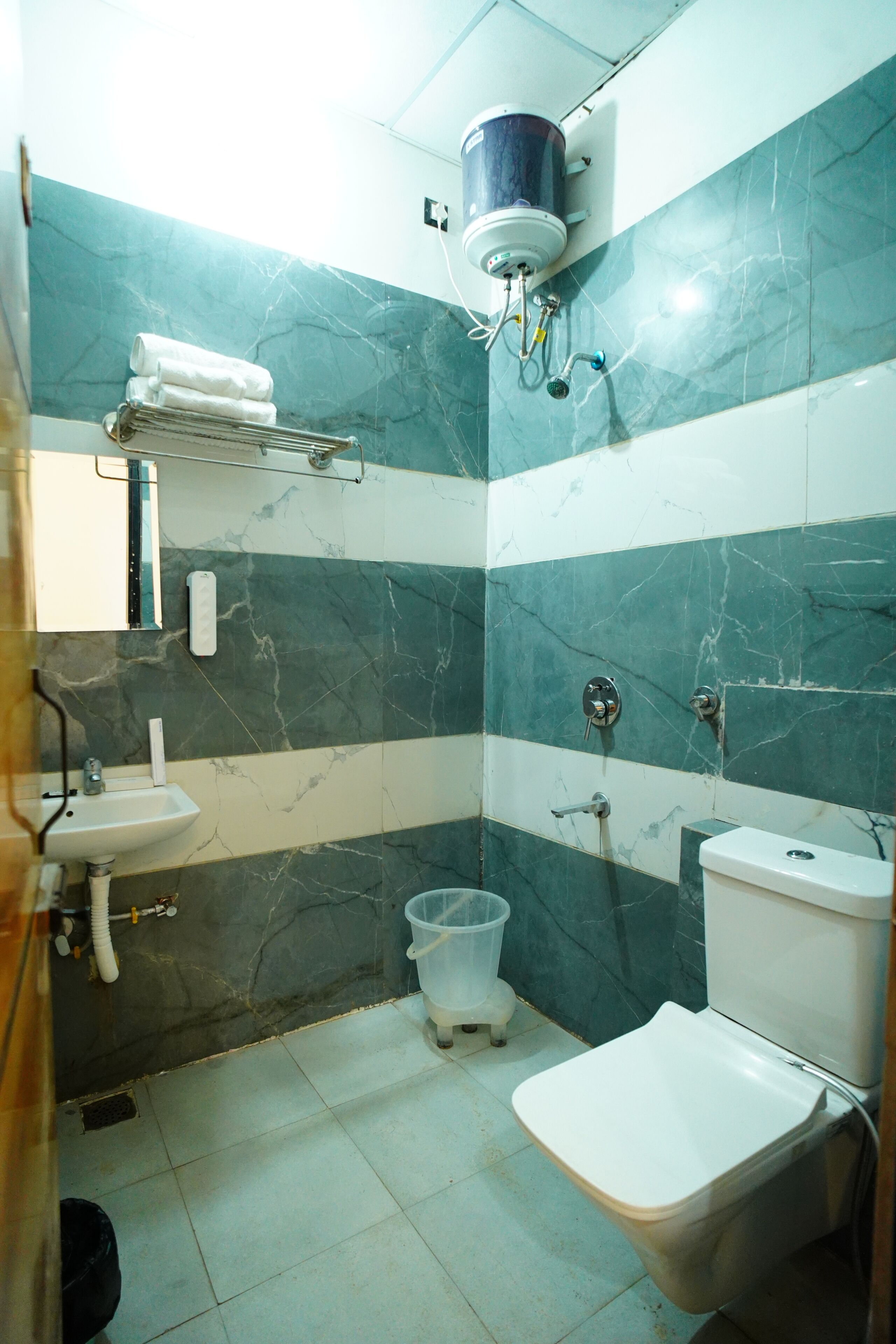 A bathroom with a toilet, sink, and shower.