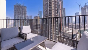 Een balkon met uitzicht op hoge gebouwen en bouwkranen.