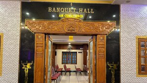 A Banquet Hall with a black and gold entrance, air conditioning, and a view of the seating area. - The Grand Krishna Rooms (Bengaluru)