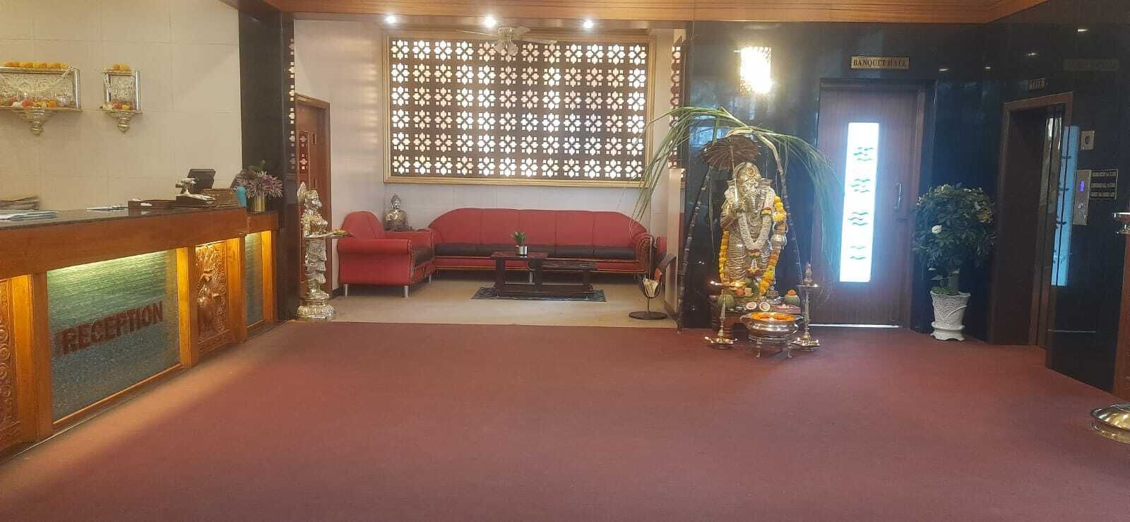 A reception area with a reception desk, a sofa, and a statue.