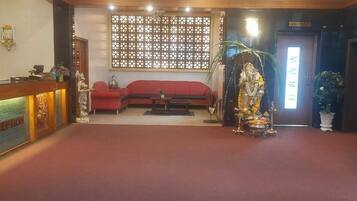 A reception area with a reception desk, a sofa, and a statue.