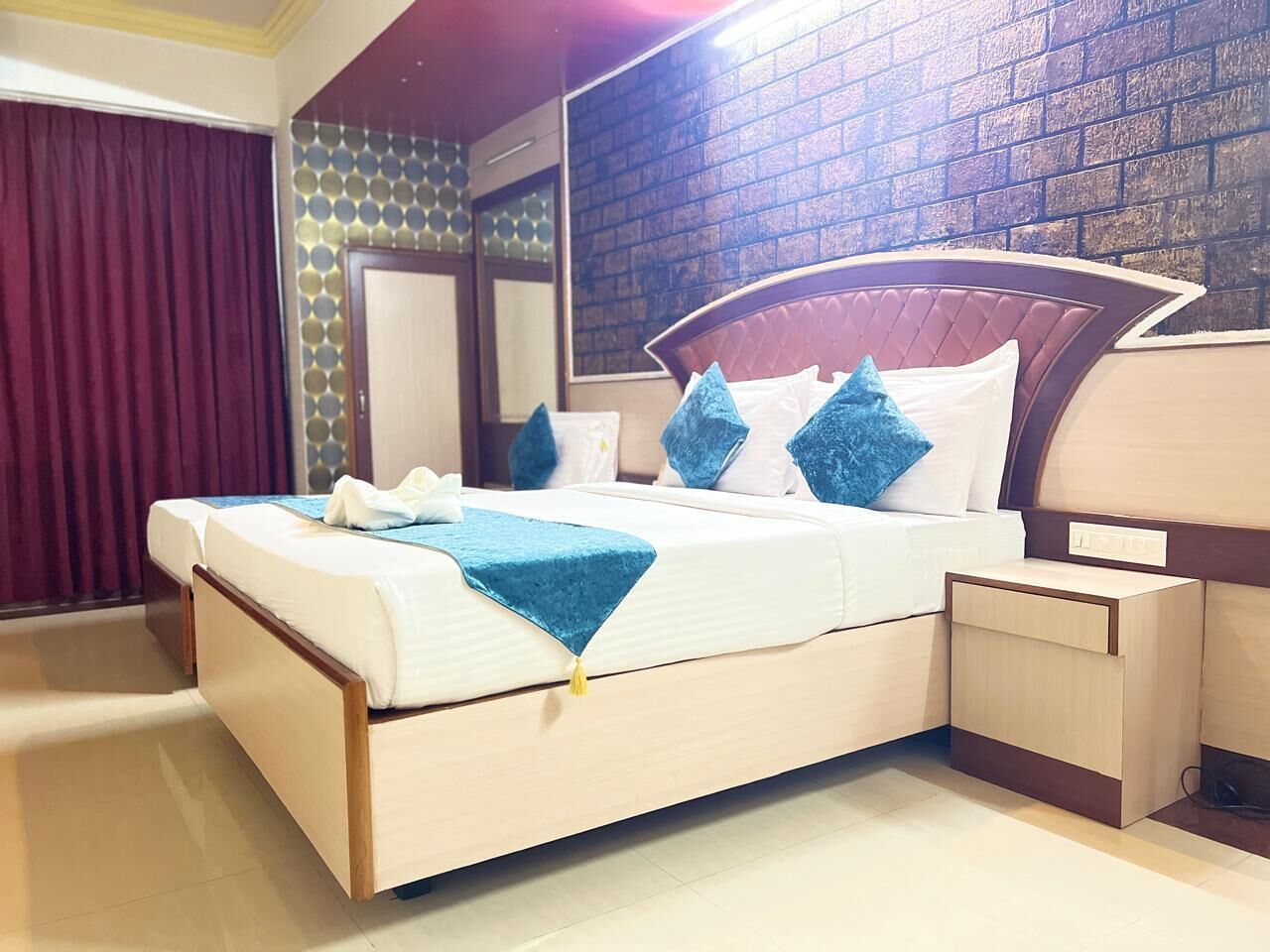 Una cama bien hecha con cabecera, una mesita de noche y una pared con diseño de ladrillo.