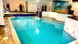 An indoor swimming pool with clear water, a diving board, and a mural of a beach scene on the wall. - 2 Bedrooms Cornish Holidays For Penzance & St Ives (Penzance)
