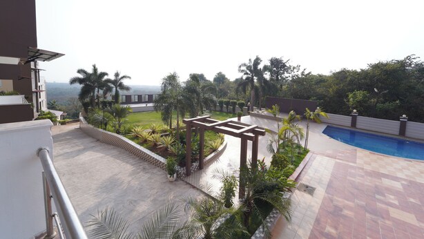 A rooftop pool area with a pergola, palm trees, and a view of the cityscape. - Ocean View The Apartment Hotel (Consua)