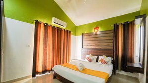 A hotel room with a bed, curtains, a headboard, and an air conditioning unit. - Ocean View The Apartment Hotel (Consua)