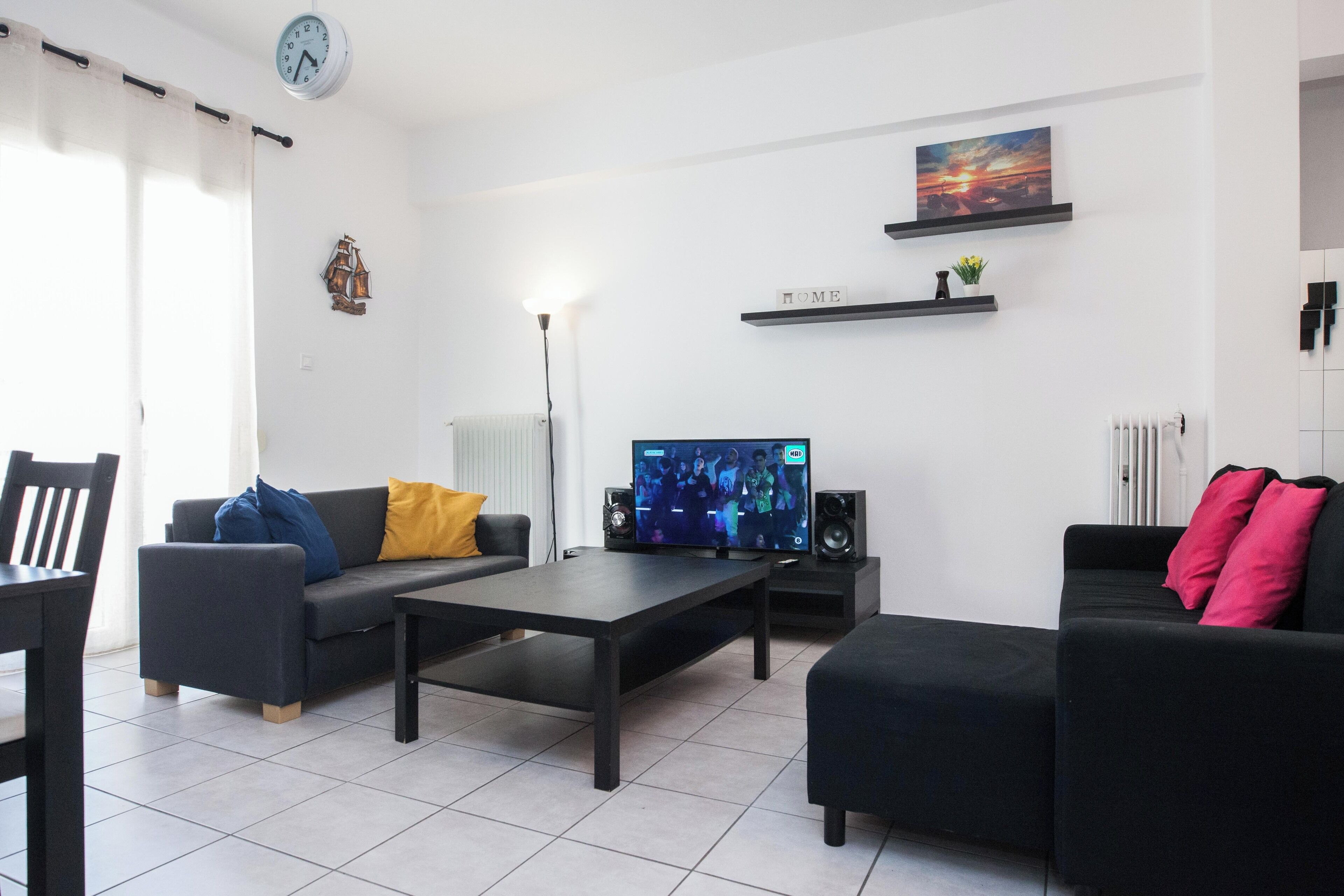 Un salon moderne doté d’un téléviseur à écran plat, de deux canapés, d’une table basse et d’un coin repas avec une chaise et une table.