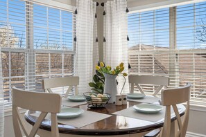 Enjoy meals with family and friends in this cozy dining area, featuring a round table for four and comfortable seating.