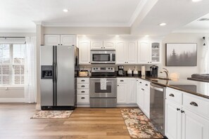 Enjoy cooking in this well-equipped kitchen with a refrigerator, oven, and microwave, plus a window with a view.