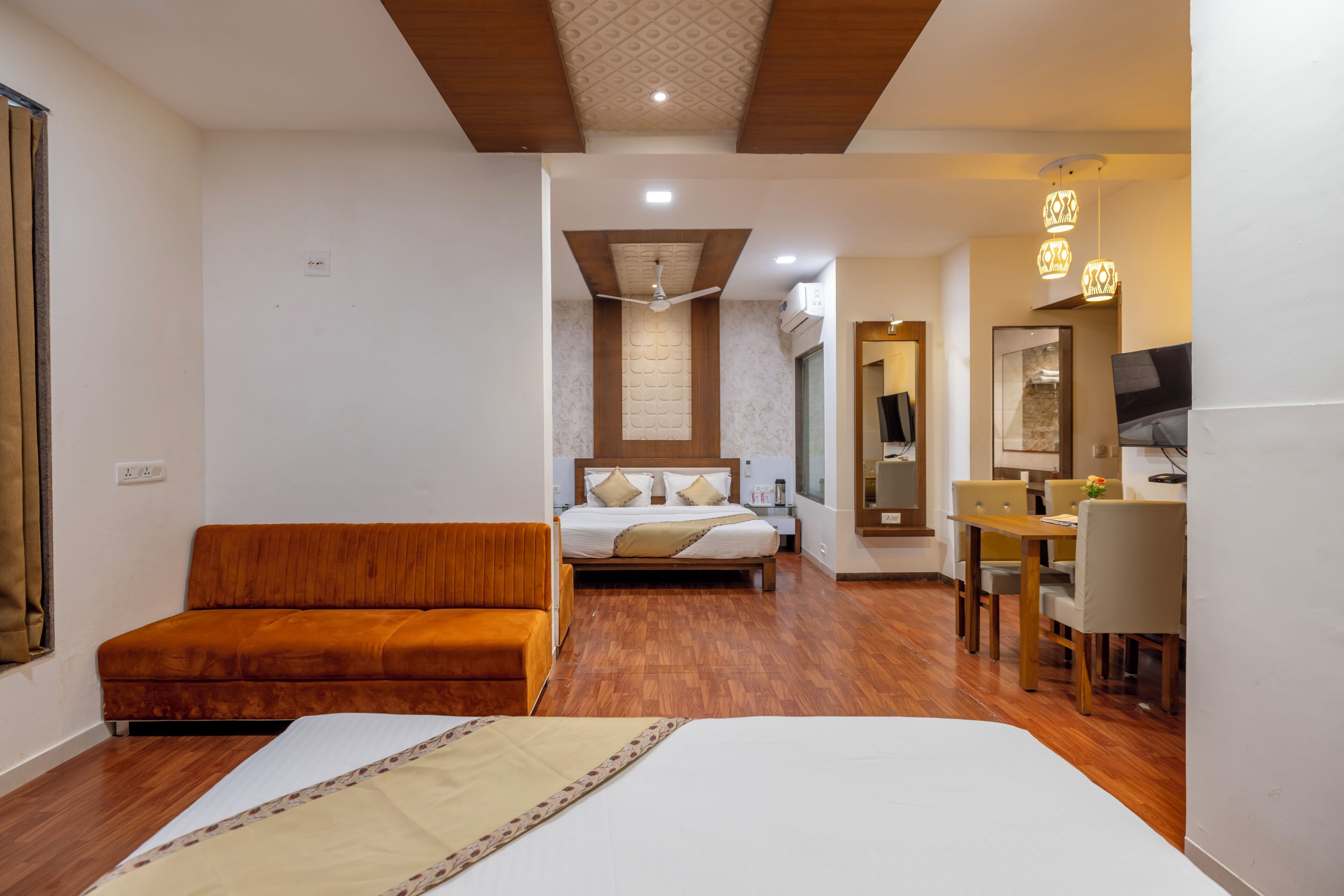 Una habitación de hotel con cama, sofá, escritorio y zona de comedor.