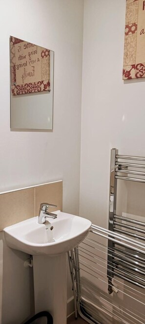 A bathroom with a white sink, a mirror, and a towel rack. - Cozy Peace in Sittingbourne (Sittingbourne)