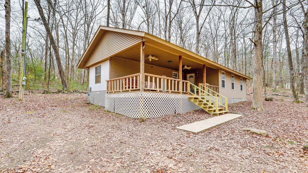 A cabin with a wooden deck, a staircase, and a fenced porch. - Heber Springs Cabin w/ Deck: 3 Mi to Sugarloaf Mtn (Heber Springs)
