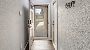 Un couloir avec une porte vitrée donnant sur un jardin.