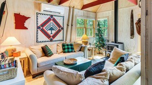 A cozy living room with a sofa, a coffee table, and a fireplace. - Riverside Retreat in Crosby: Pet Friendly! (Crosby)