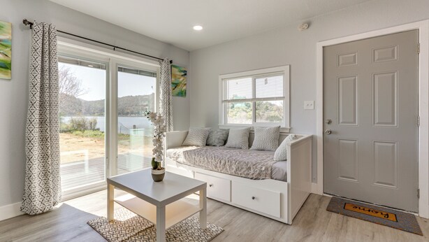 A room with a bed, a table, and a view of the outdoors. - End Unit w/ Clear Lake Access in Norcal! (Clearlake)