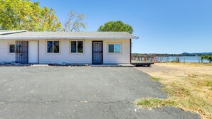 A single-story house with a front porch, a garage, and a view of a lake. - End Unit w/ Clear Lake Access in Norcal! (Clearlake)