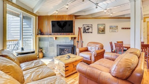 Una sala de estar acogedora con chimenea, sofás de cuero y una mesa de centro de madera.