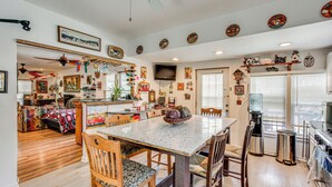 Una cocina amplia con una isla central, sillas de madera y una mesa de comedor.