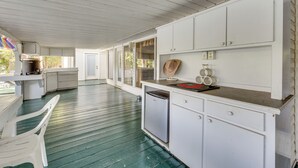 A covered outdoor kitchen with a refrigerator, a sink, and a countertop. - Waterfront Jonesville Studio on Black River Lake! (Jonesville)