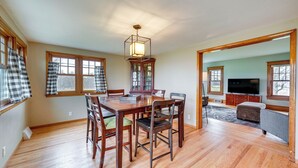 A spacious living room with a wooden dining table, chairs, and a television. - Charming Tonica Farmhouse w/ Private Yard! (Tonica)