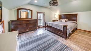 A bedroom with a large bed, dresser, and mirror. - Charming Tonica Farmhouse w/ Private Yard! (Tonica)