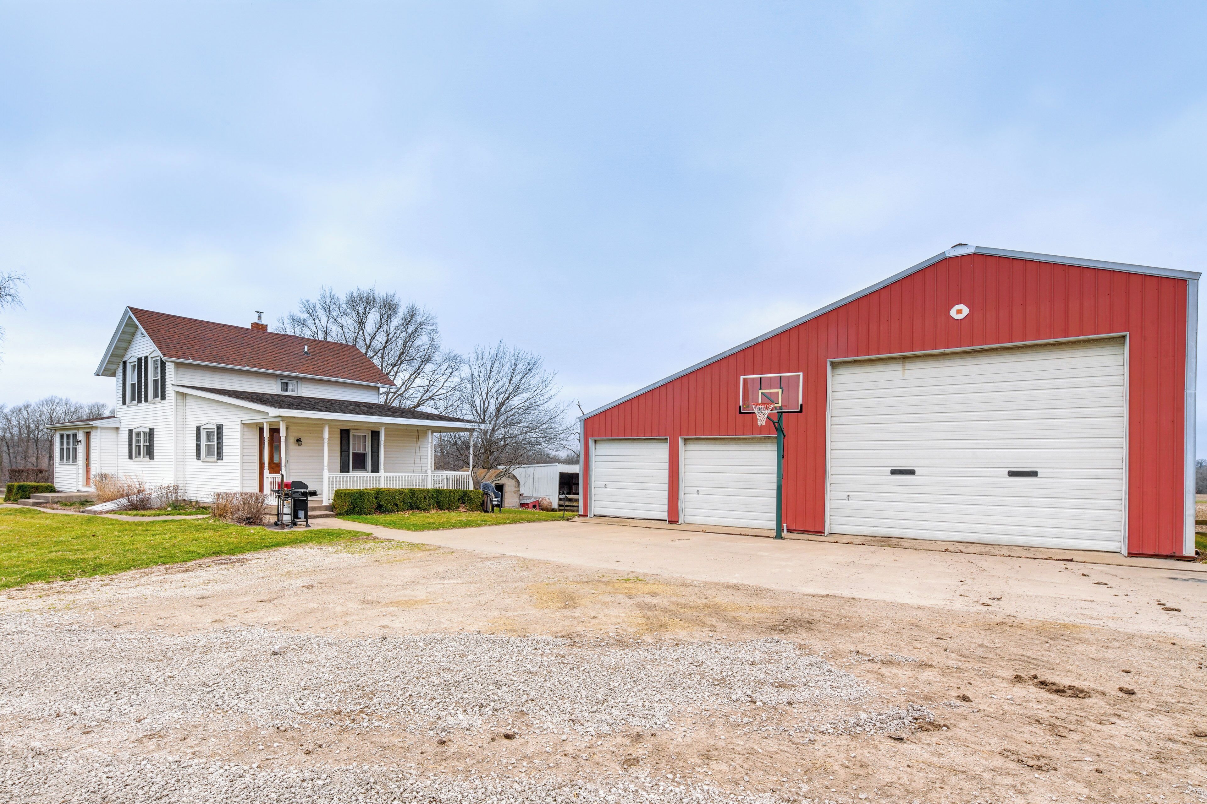 A residential area with a white house and a red garage.