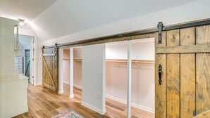 A hallway with a sliding barn-style door leading to a closet with hanging rods. - 3 Mi to Silver Springs State Park: Cozy Getaway! (Silver Springs)
