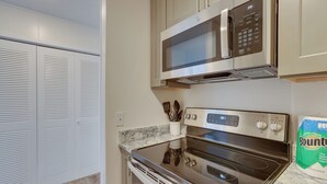 A kitchen with a stainless steel microwave, oven, and a set of knives in a holder. - Studio in Gadsden ~ 10 Mi to the Coosa River! (Gadsden)