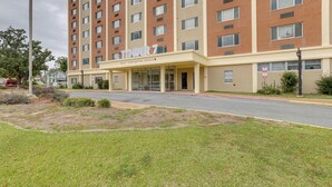 A multi-story hotel with a prominent entrance labeled "Tower 7" and a sign indicating it is a "Rustler Comforter House." - Studio in Gadsden ~ 10 Mi to the Coosa River! (Gadsden)