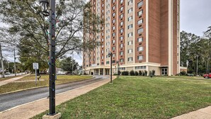A multi-story building with a one-way street sign, a grassy area, and a sidewalk. - Airy Apt Situated in the Coosa River Area! (Gadsden)