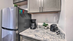 A kitchen with a stainless steel refrigerator, a coffee maker, a toaster, and a potted plant on the counter. - Airy Apt Situated in the Coosa River Area! (Gadsden)