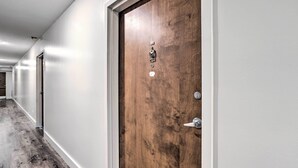 A hallway with a wooden door, a metal handle, and a keyhole. - Airy Apt Situated in the Coosa River Area! (Gadsden)