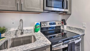 A kitchen with stainless steel appliances, a granite countertop, a sink, and a bag of Bounty paper towels. - Airy Apt Situated in the Coosa River Area! (Gadsden)