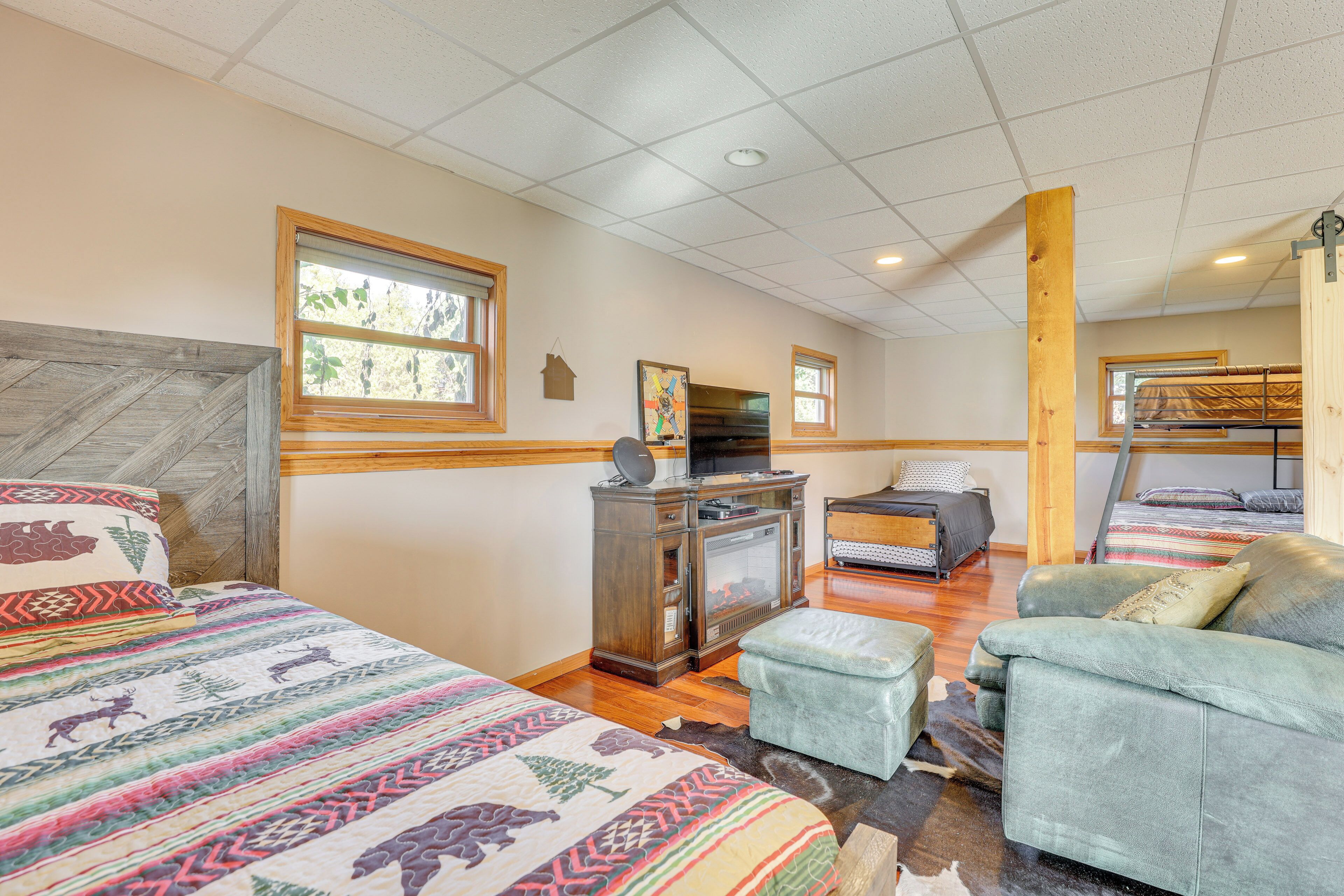 A bedroom with two beds, a sofa, a TV, and a wooden cabinet.