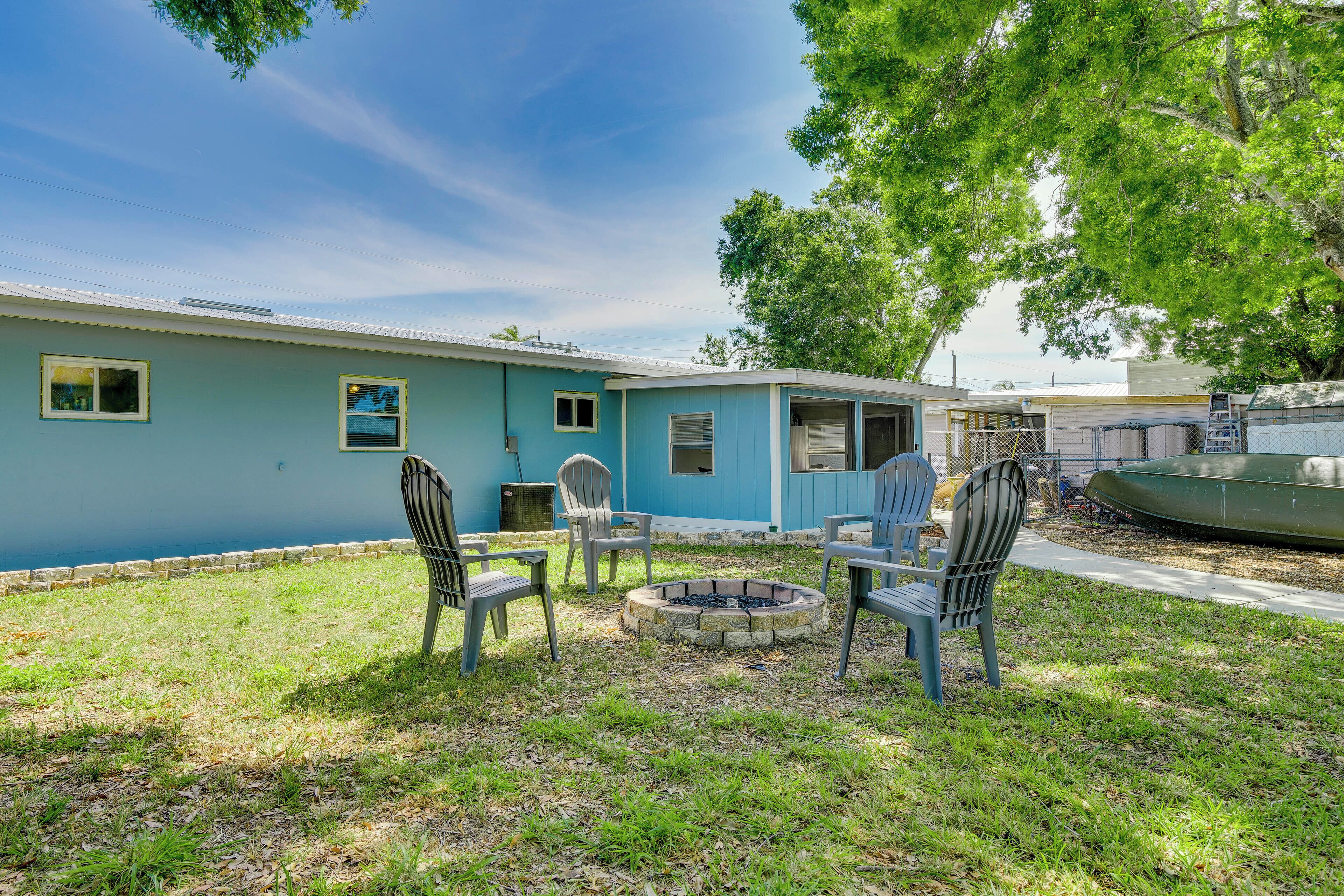 A blue house with a fire pit and outdoor seating.