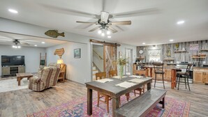 Un vaste espace de vie comprenant une table à manger, un canapé et un ventilateur de plafond.