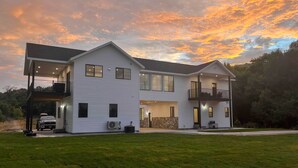 A modern two-story house with a covered porch, a car parked in the driveway, and a well-maintained lawn. - Preston Summer Getaway: Sugar Creek Apartment (Preston)