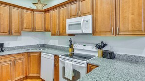 A kitchen with wooden cabinets, a microwave, a stove, and a dishwasher. - 3 Mi to Warren Dunes: Sawyer Getaway w/ Fireplace! (Sawyer)