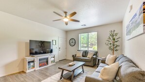 A living room with a television, sofa, coffee table, and a fireplace.