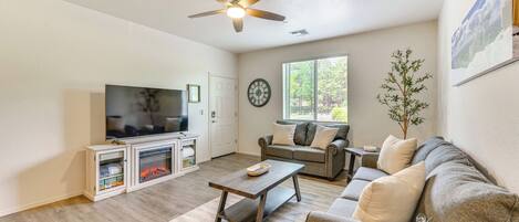 A living room with a television, sofa, coffee table, and a fireplace.