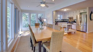 A spacious kitchen with modern appliances, a dining area with a large table and wicker chairs, and large windows providing natural light. - Lakefront Lineville Retreat w/ Private Dock! (Lineville)
