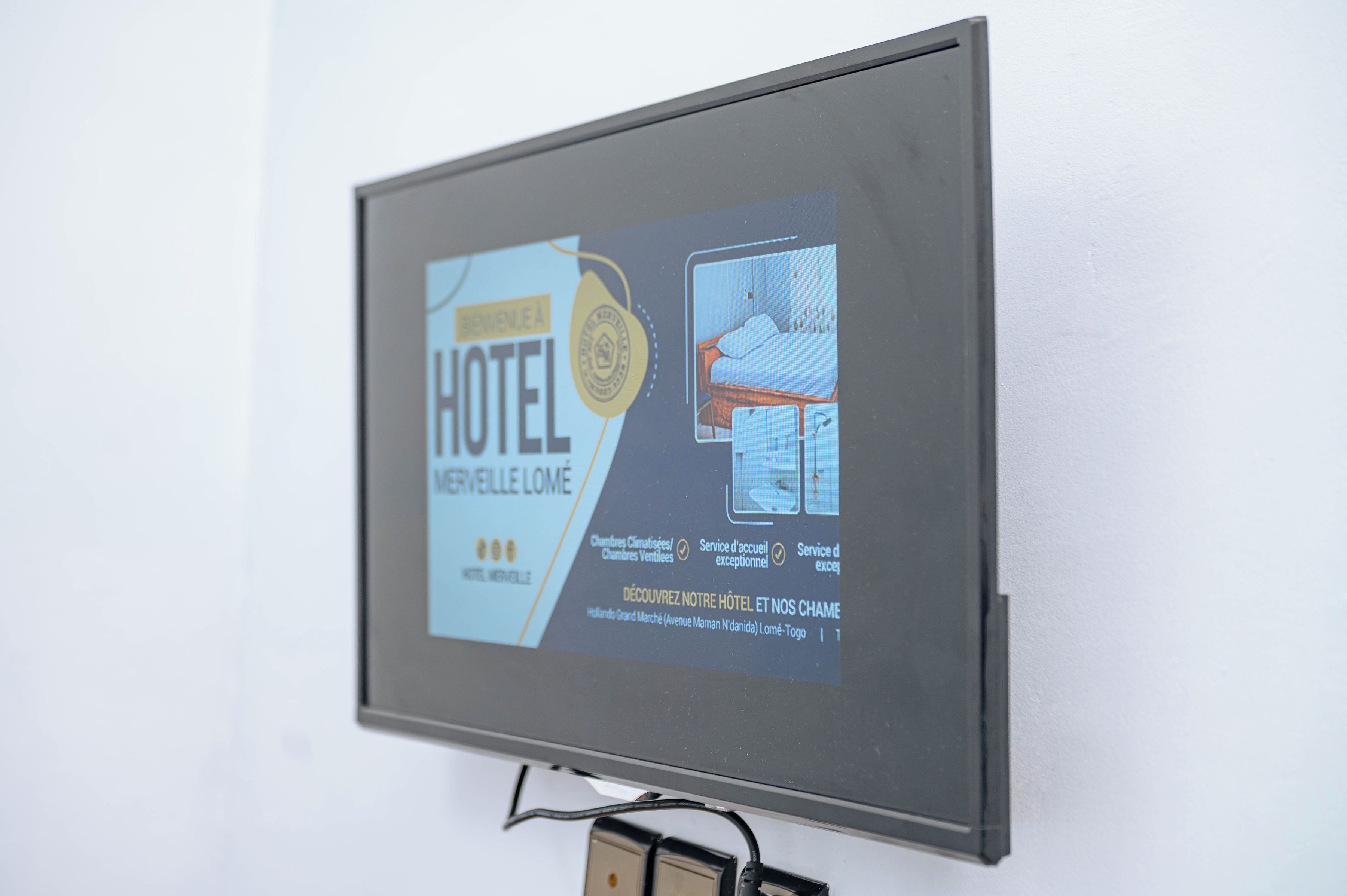 Een hotelschild met een afbeelding van een bed, informatie over de voorzieningen in de kamers en details over de locatie.