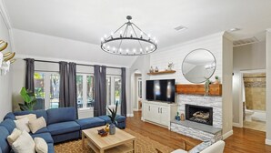 A spacious living room with a blue sofa, a wooden coffee table, and a fireplace.