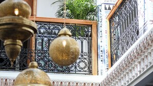 A traditional interior with ornate metal railings and hanging brass lamps. - Riad Palais MERYEM (Marrakech)