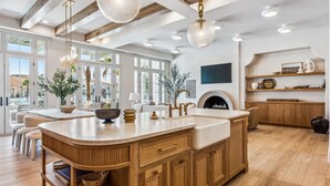 A spacious kitchen with a large island, wooden cabinets, and pendant lighting.