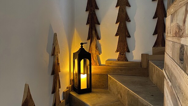 A staircase with wooden steps and a lantern on the landing.